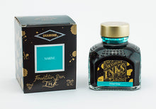 Load image into Gallery viewer, A glass bottle of 80ml Diamine Marine fountain pen ink next to its packaging box, in front of a white background.
