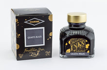 Load image into Gallery viewer, A glass bottle of 80ml Diamine Quartz Black fountain pen ink next to its packaging box, in front of a white background.
