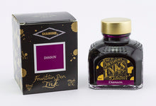 Load image into Gallery viewer, A glass bottle of 80ml Diamine Damson fountain pen ink next to its packaging box, in front of a white background.
