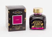 Load image into Gallery viewer, A glass bottle of 80ml Diamine Claret fountain pen ink next to its packaging box, in front of a white background.
