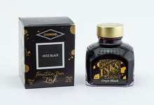 Load image into Gallery viewer, A glass bottle of 80ml Diamine Onyx Black fountain pen ink next to its packaging box, in front of a white background.
