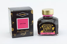 Load image into Gallery viewer, A glass bottle of 80ml Diamine Hope Pink fountain pen ink next to its packaging box, in front of a white background.
