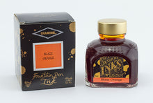 Load image into Gallery viewer, A glass bottle of 80ml Diamine Blaze Orange fountain pen ink next to its packaging box, in front of a white background.
