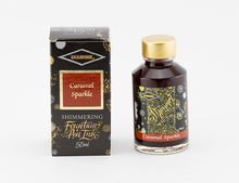Load image into Gallery viewer, A glass bottle of 50ml Diamine Caramel Sparkle shimmering fountain pen ink next to its packaging box, in front of a white background.
