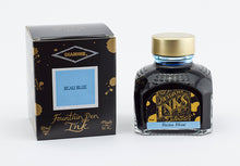 Load image into Gallery viewer, A glass bottle of 80ml Diamine Beau Blue fountain pen ink next to its packaging box, in front of a white background.
