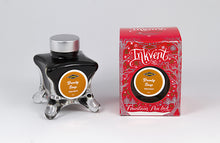 Load image into Gallery viewer, A glass bottle of 50ml Diamine Red Edition Inkvent Brandy Snap fountain pen ink next to packaging box, in front of a white background.
