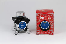 Load image into Gallery viewer, A glass bottle of 50ml Diamine Red Edition Inkvent Storm shimmer fountain pen ink next to packaging box, in front of a white background.
