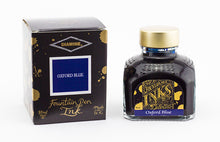 Load image into Gallery viewer, A glass bottle of 80ml Diamine Oxford Blue fountain pen ink next to its packaging box, in front of a white background.
