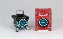 Load image into Gallery viewer, A glass bottle of 50ml Diamine Red Edition Inkvent Stargazer Shimmer fountain pen ink next to packaging box, in front of a white background.
