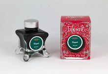 Load image into Gallery viewer, A glass bottle of 50ml Diamine Red Edition Inkvent Tempest Shimmer fountain pen ink next to packaging box, in front of a white background.
