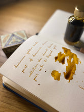 Load image into Gallery viewer, A colour swatch and writing swatch of Diamine Golden Sands shimmering fountain pen ink.
