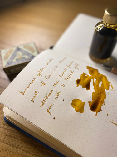 A colour swatch and writing swatch of Diamine Golden Sands shimmering fountain pen ink.