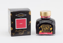 Load image into Gallery viewer, A glass bottle of 80ml Diamine Ruby fountain pen ink next to its packaging box, in front of a white background.
