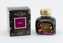 Load image into Gallery viewer, A glass bottle of 80ml Diamine Merlot fountain pen ink next to its packaging box, in front of a white background.
